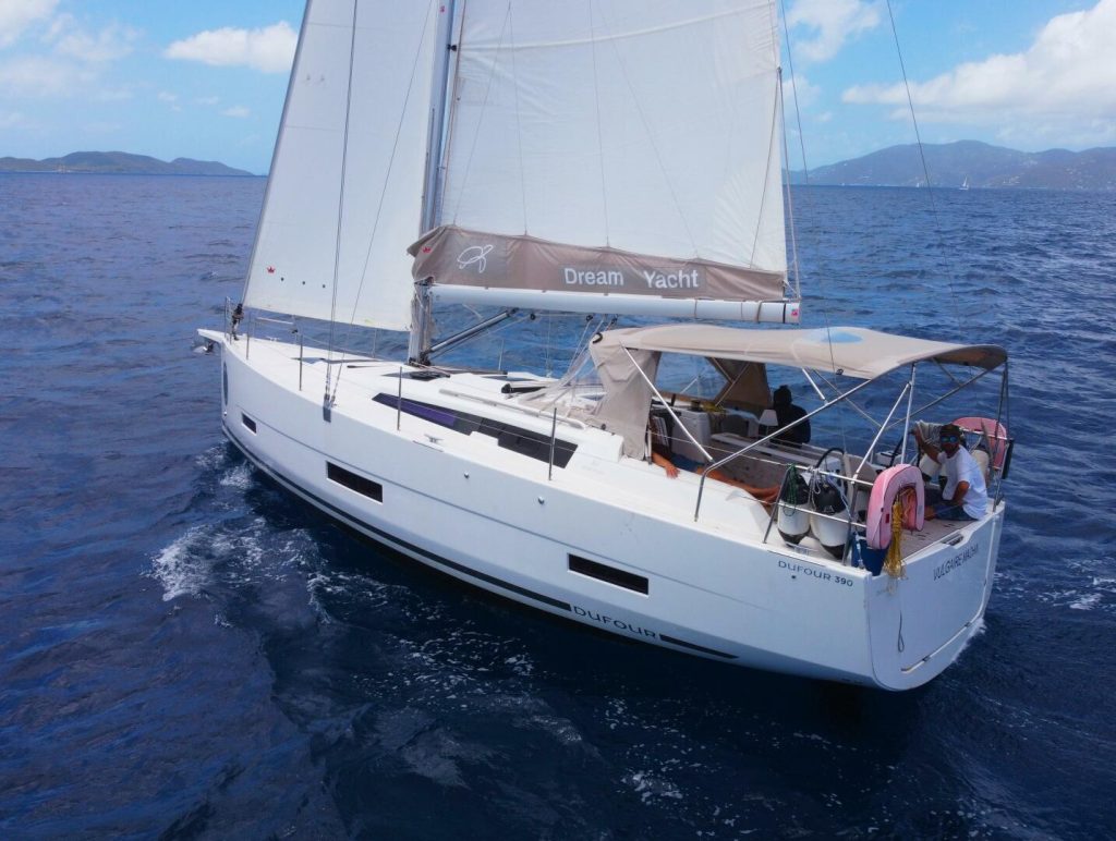 Aerial drone view of the 2023 Dufour 390 Grand Large sailing under full main in the British Virgin Islands