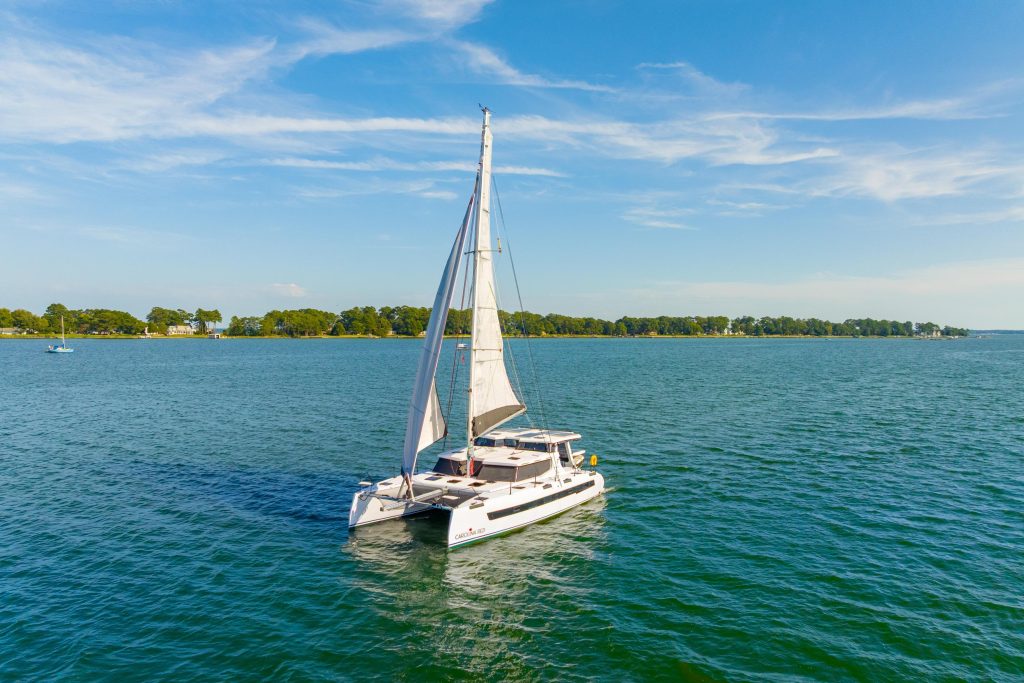 2024 St Francis 460 Hybrid Carolina Red at anchor showing her carbon-wrapped hulls and Awlgrip white finish