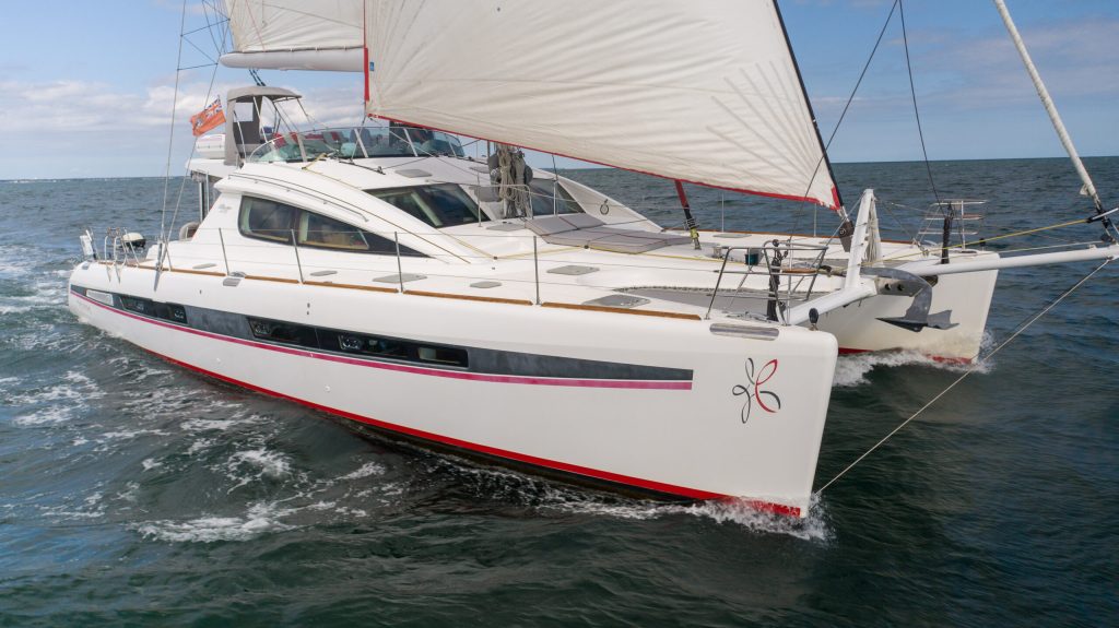 Interior of S/V Tehiya showing the full-beam owner's suite with walkaround king berth and natural light
